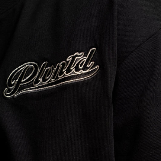 Black t-shirt with PLVNTD logo on a gray background